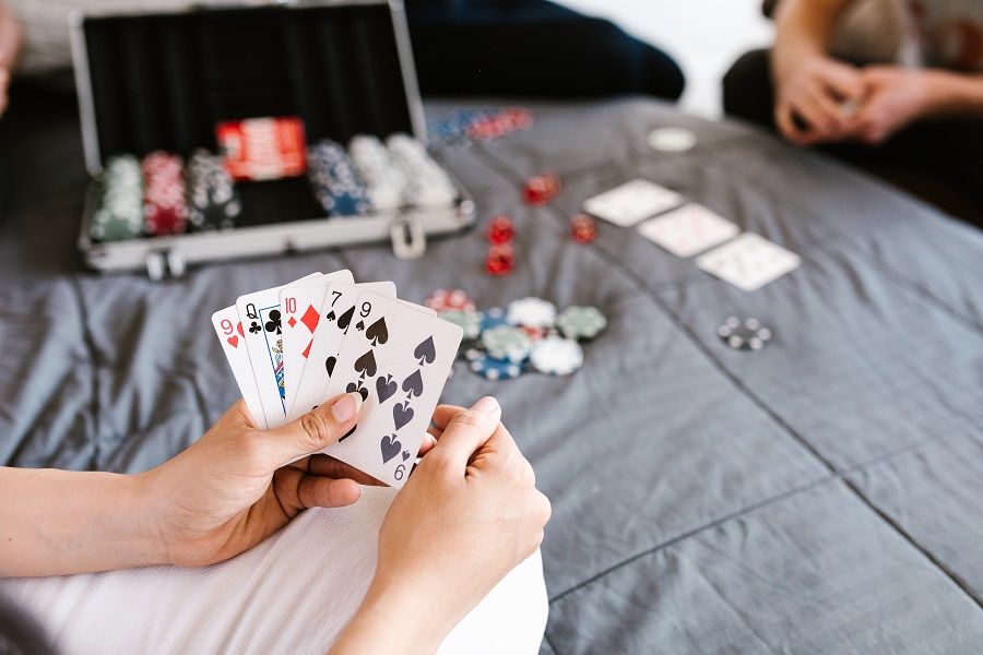 two people playing poker on the bed