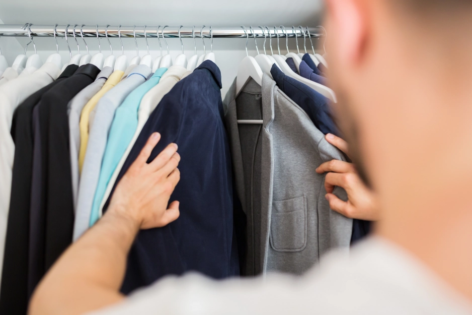 man looking in a wardrobe